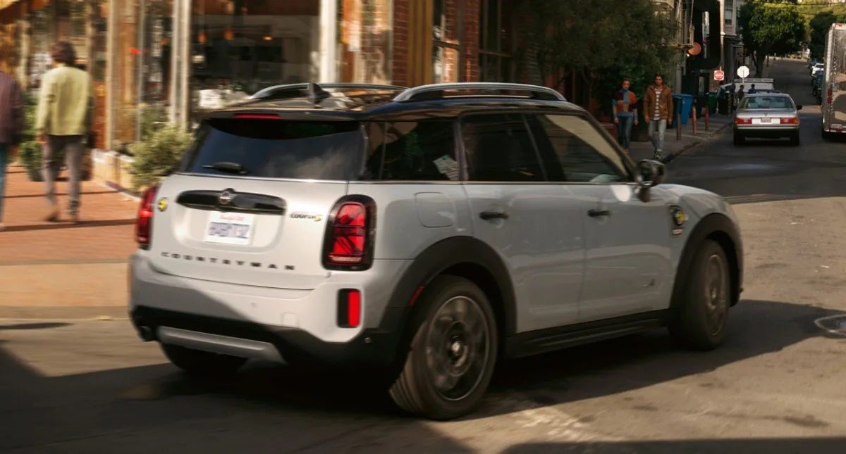 The MINI Cooper SE Countryman PHEV turning a corner in the city. MINI of Morristown in Morristown NJ