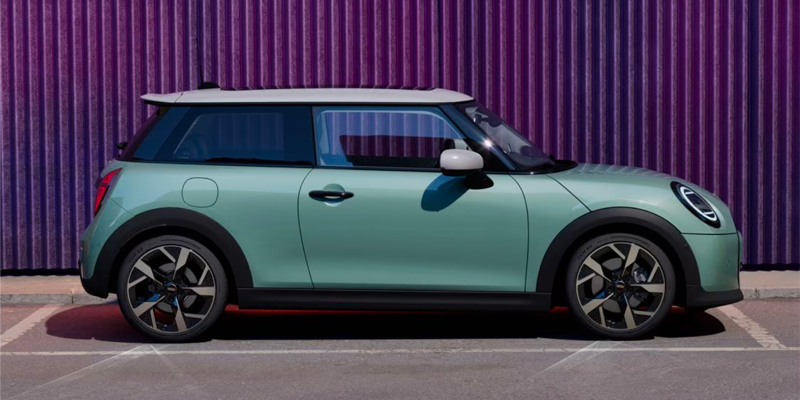 A mint green 2025 MINI Cooper S 2-Door parked beside a purple striped wall.