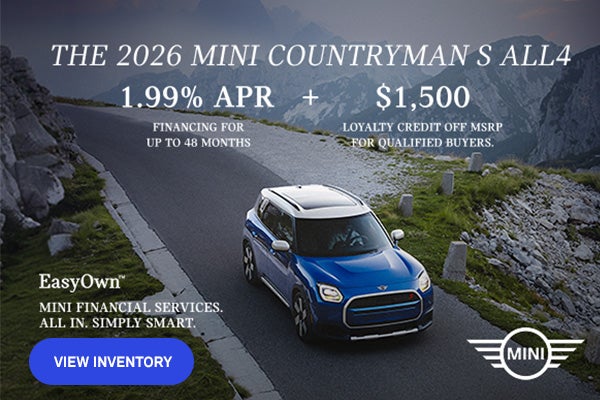 Front passenger side view of a MINI Countryman driving on a mountainous road.