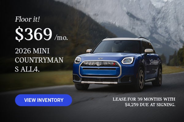 Front view of a blue MINI Countryman driving on a mountainous road.