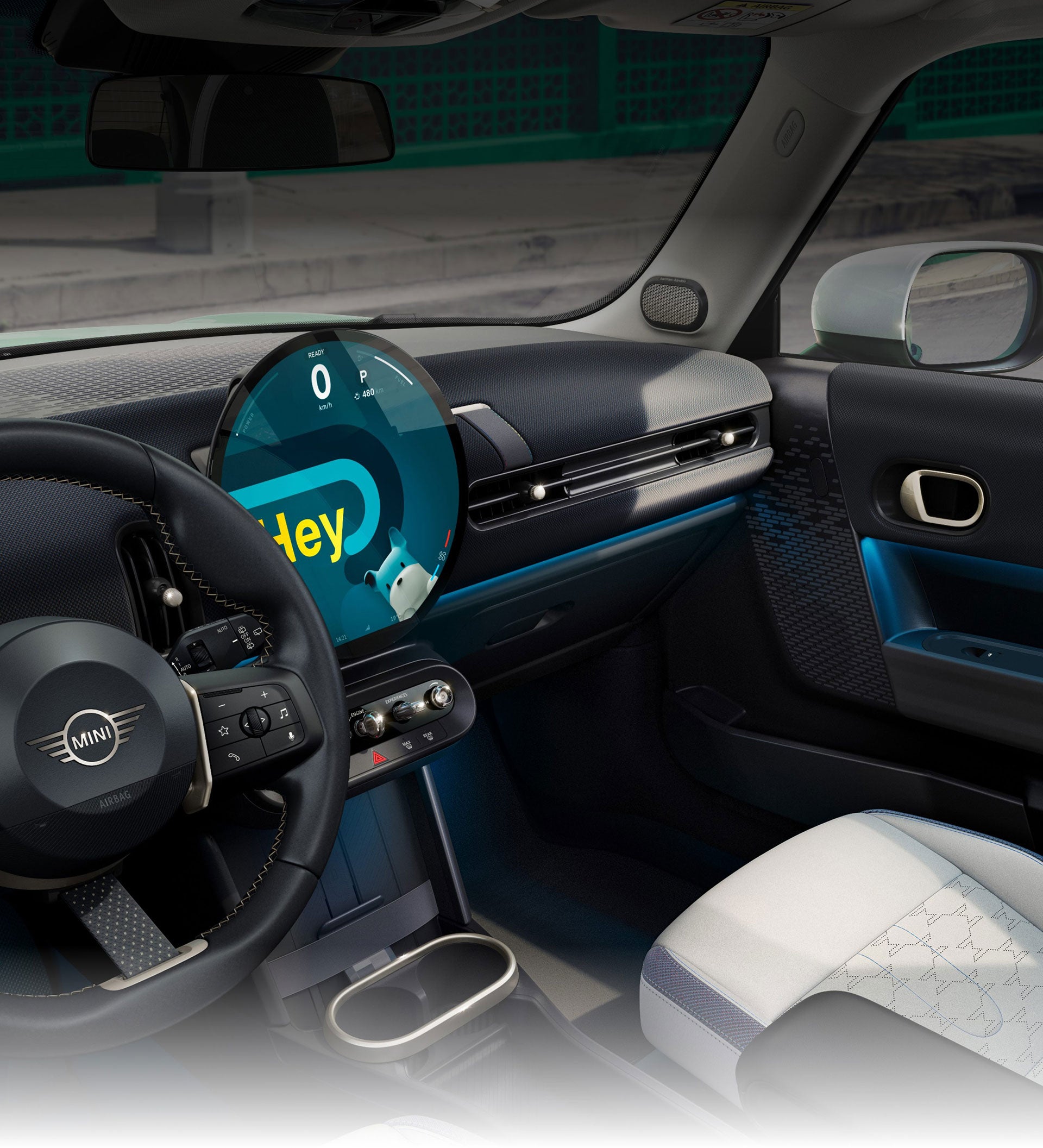 An angled-view of the inside of the Mini Cooper Hardtop 2 Door taken from the passenger's side showcasing the front Sports Seats with blue skies and trees out the windows.